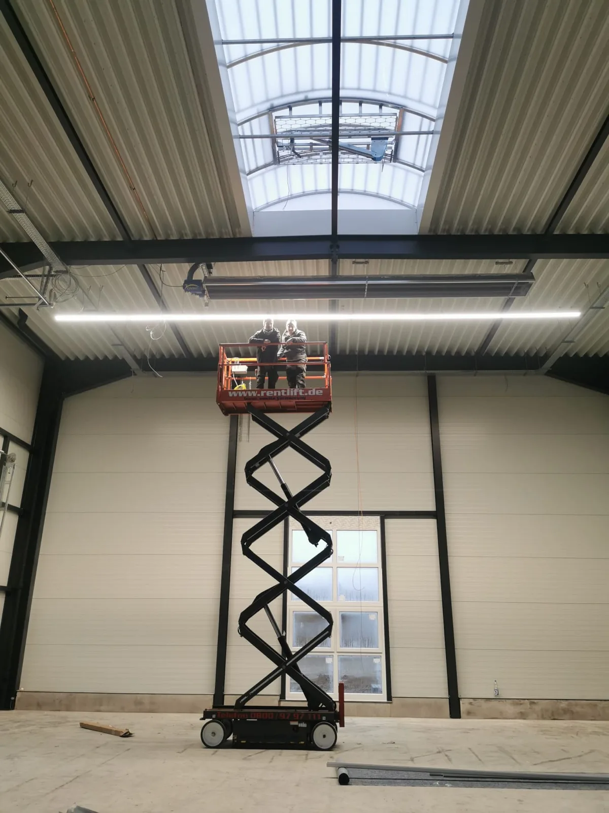Zwei Mitarbeiter von Mössner bei der Hallenmontage auf der Hebebühne
